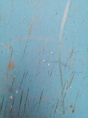 old damaged blue metal surface with vertical scratches
