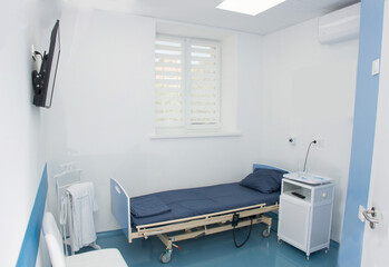 Modern empty and clean hospital room with medical equipment and TV
