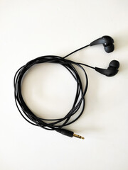 Black wire headphones on white desk.

Zagreb, Croatia - February 2nd 2021