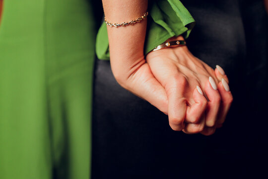 Interracial lesbian women hold hands and embrace each other have different skin conditions stand against green background. All skin is beautiful.