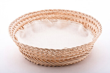 Empty wicker basket with cloth napkin, isolated on white background