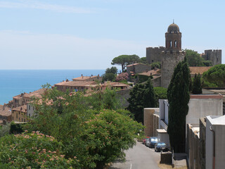Fototapeta na wymiar Panorama of the fortified medieval village of Castiglione della Pescaia perched on the top of a hill with the Tyrrhenian Sea in the background.
