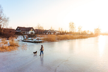 Person walking dog on fozen river