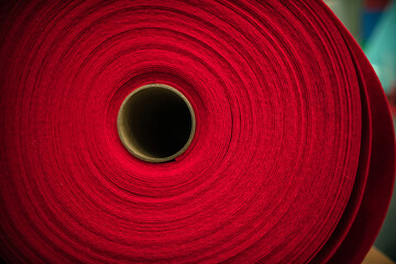 Fototapeta na wymiar A large ball of red felt twisted into a tube. manufacture of textiles