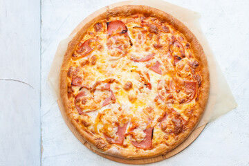 Pizza with mozzarella cheese, ham, tomatoes and sauce on plain grey background