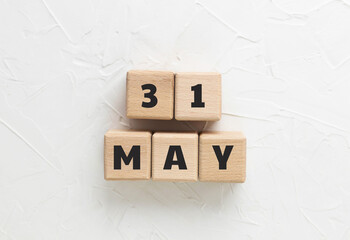 Text 31 MAY made of wood cubes on white textured putty background. Memorial Day 2021. American...