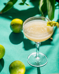 yellow tropical cocktail on a background of foliage, shadows from the sun. Green background