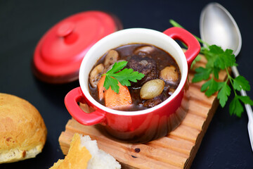 Boeuf bourguignon in einem  Topf mit Baguette 
