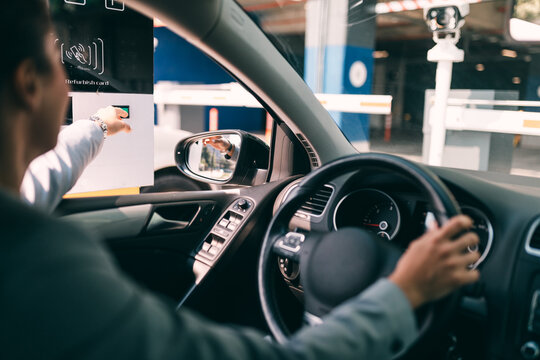 Woman Is Driving Into A Parking Garage And Is Collecting Ticket From Car Park Machine.