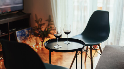 Two glasses of red wine on a black table, romantic atmosphere at home
