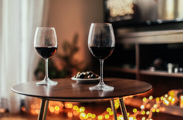 Two glasses of red wine on a black table, romantic atmosphere at home