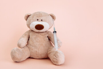 Stuffed Bear animal with syringe isolated with copy space. Children doctor theme.