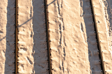 Train rails and tracks in the snow at sunset