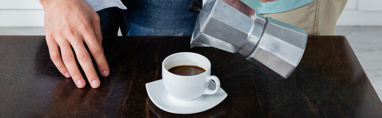partial view of homosexual man pouring coffee from coffee pot near husband, banner