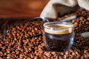 Cup of coffee on wooden table with coffee beans 