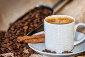 Cup of coffee on wooden table with coffee beans 