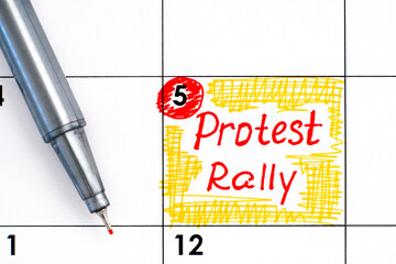 Reminder Protest Rally in calendar with pen.