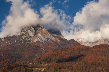 Beautiful mountain landscape with mount peaks in clouds on a sunny d
