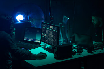 Wanted hackers coding virus ransomware using laptops and computers. Cyber attack, system breaking and malware concept.