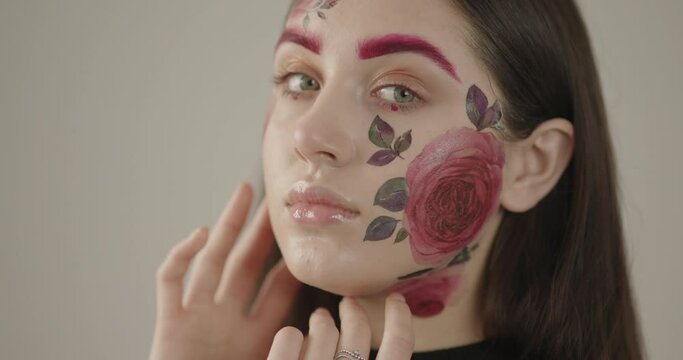 close-up of a beautiful girl with delicate flowers on her face. Symbol of spring and female beauty