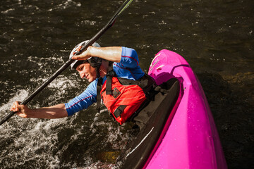Whitewater kayaking, extreme sport rafting. Guy in kayak sails mountain river.