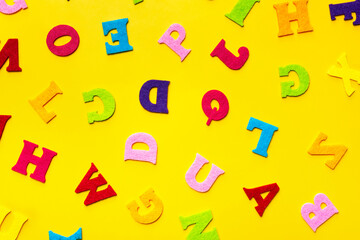 English alphabet letters on a yellow background pattern.