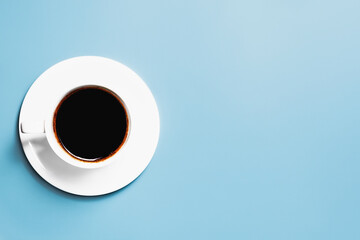 Cup of coffee on a light blue background with blank space.