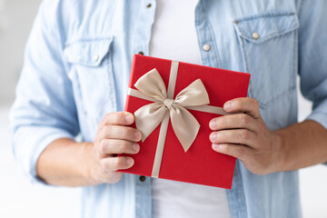 Man holds gift box in his hands, close-up.
