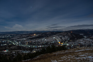 Panorama of a winter village at night in the mountains