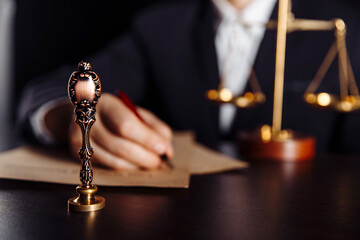 Man signing a Last Will and Testament document in notary public office. Stamp in focus.