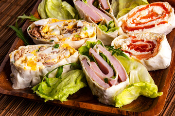 Sliced spring rolls with salmon, tuna fish, ham, egg and green vegetables.