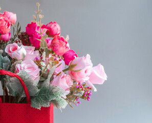Flower series.Pink and red roses in a red box on a gray background