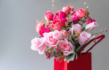 Flower series.Pink and red roses in a red box on a gray background