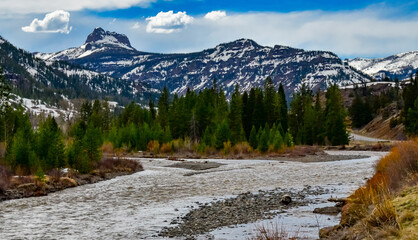 Fototapeta premium Mountain river with muddy water, melting snow in the mountains. Mountain landscape.