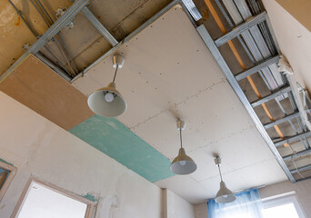 Unfinished two-level plasterboard ceiling in the interior of a room in a new building