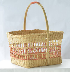A traditional colourful rattan basket with handles