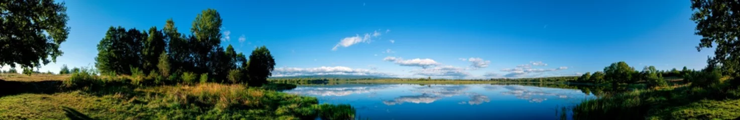 Foto op Canvas Panoramic view of a calm lake on a sunny summer day © mikhailgrytsiv