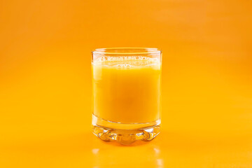 Orange juice in a glass on an orange background. Concept. Healthy eating.