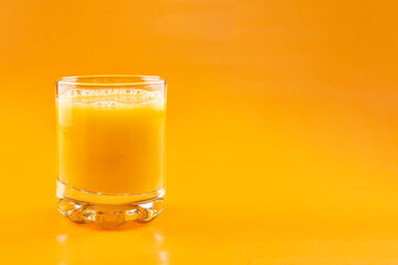 Orange juice in a glass on an orange background. Concept. Healthy eating.