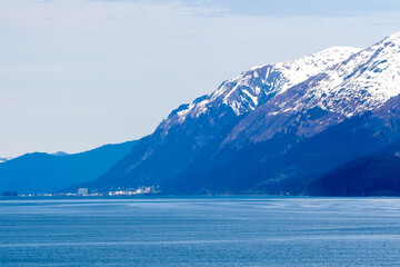 Snow-capped mountains and small town along the coast of southern Alaska