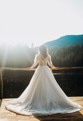Beautiful bride in luxury wedding dress near the lake. Wedding in mountains