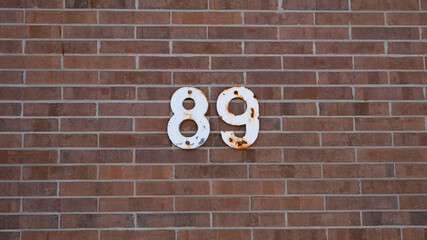Number 89 with rust on red brick background