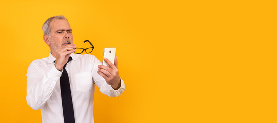 isolated senior adult man with presbyopia or eyestrain looking at phone
