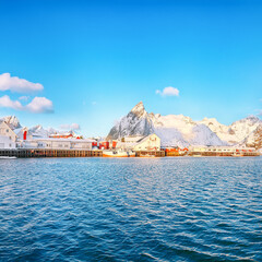 Fantastic winter view on Hamnoy village with port and  Olstinden peak on background.