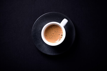 Cup of coffee on black background. Top view. Copy space
