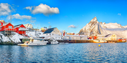 Fantastic winter view on Hamnoy village with port and  Olstinden peak on background.