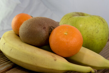 un bel mix di frutta invernale, banane mandarini e kiwi, frutti colorati in posa, la salute e l'alimentazione