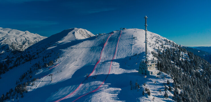 Aerial Panorama Of Ski Slope Of Krvavec In Slovenia, Visible TV Tower Or Antenna And Also A Ski Race Course Between The Red Fence.