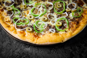 Pizza deliciosa com ingredientes na mesa de madeira com fundo escuro.