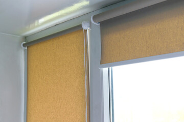 close up of brown roller blinds, shades on plastic windows at home, renovation concept